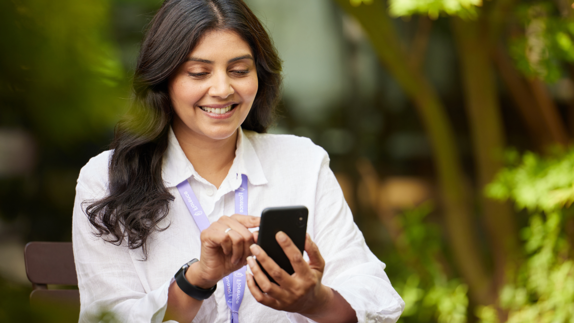 Female manager using mobile phone to manage bank staff and streamline processes with Bank Manager